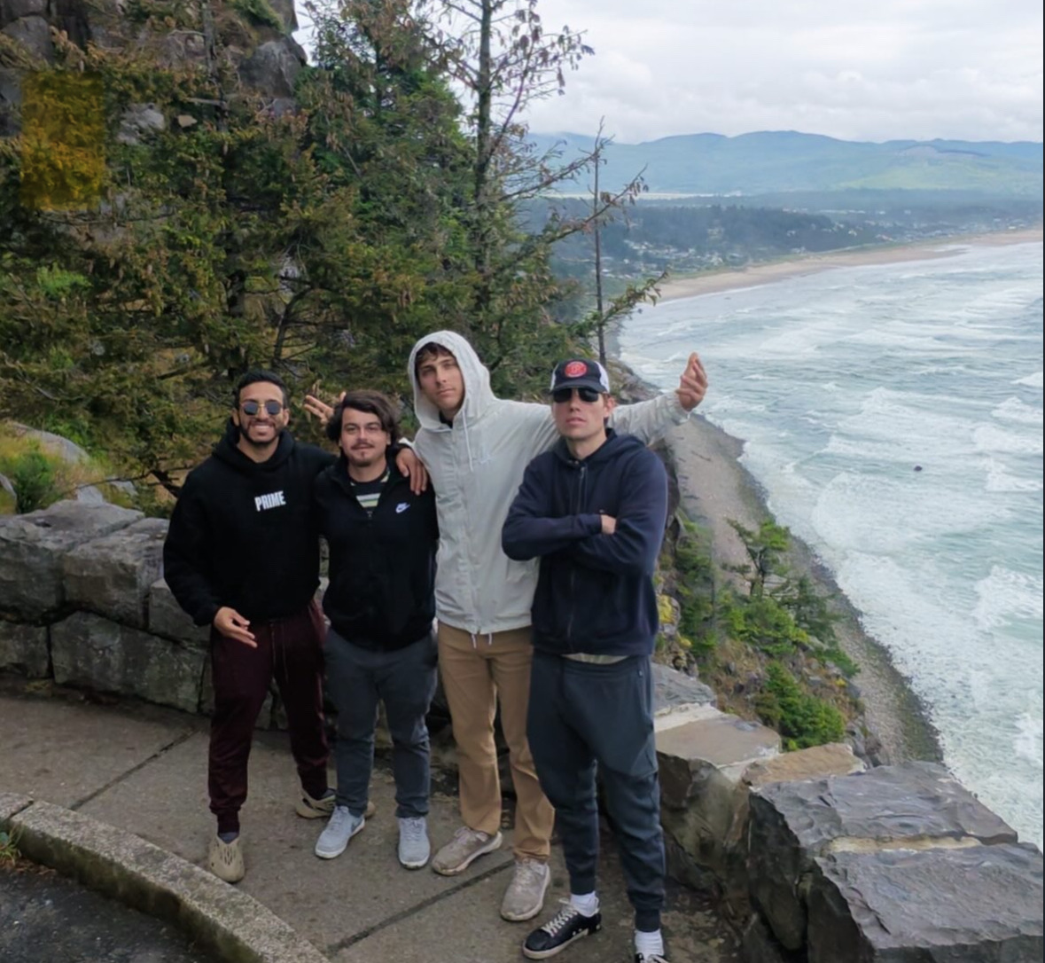 Four people together at a coastal overlook.